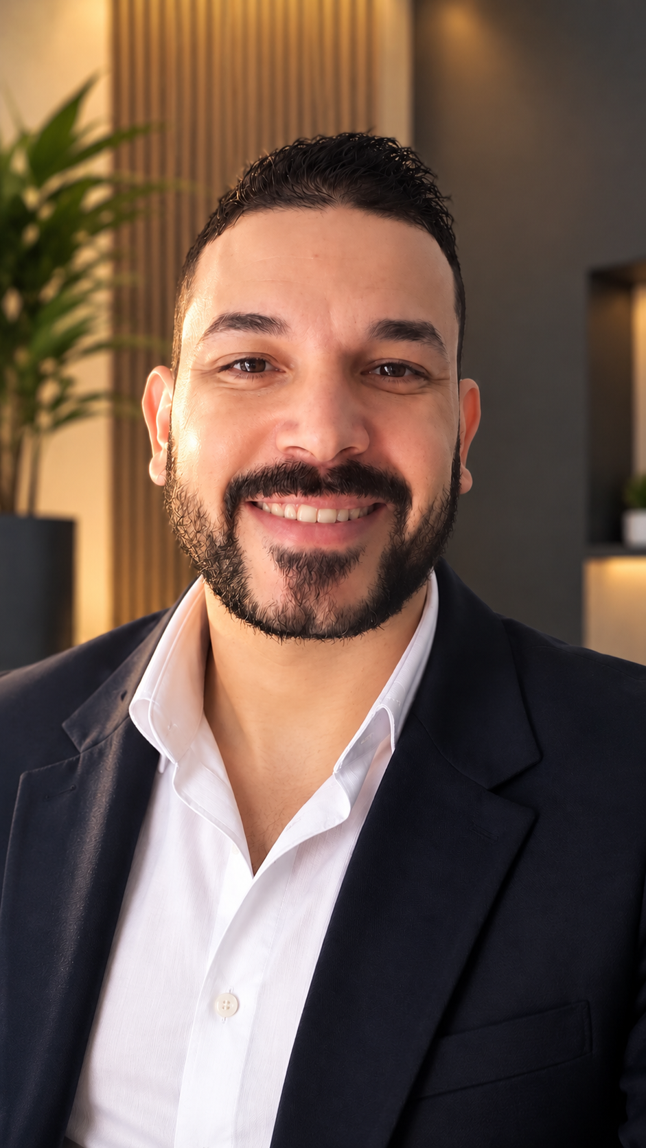 Adezil Ferreira sorrindo, de blazer preto e camisa branca